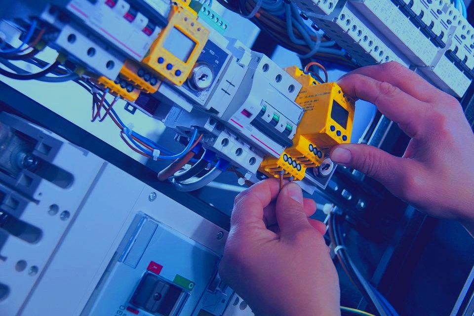Revizní technik kontroluje jističe v elektrickém rozvaděči